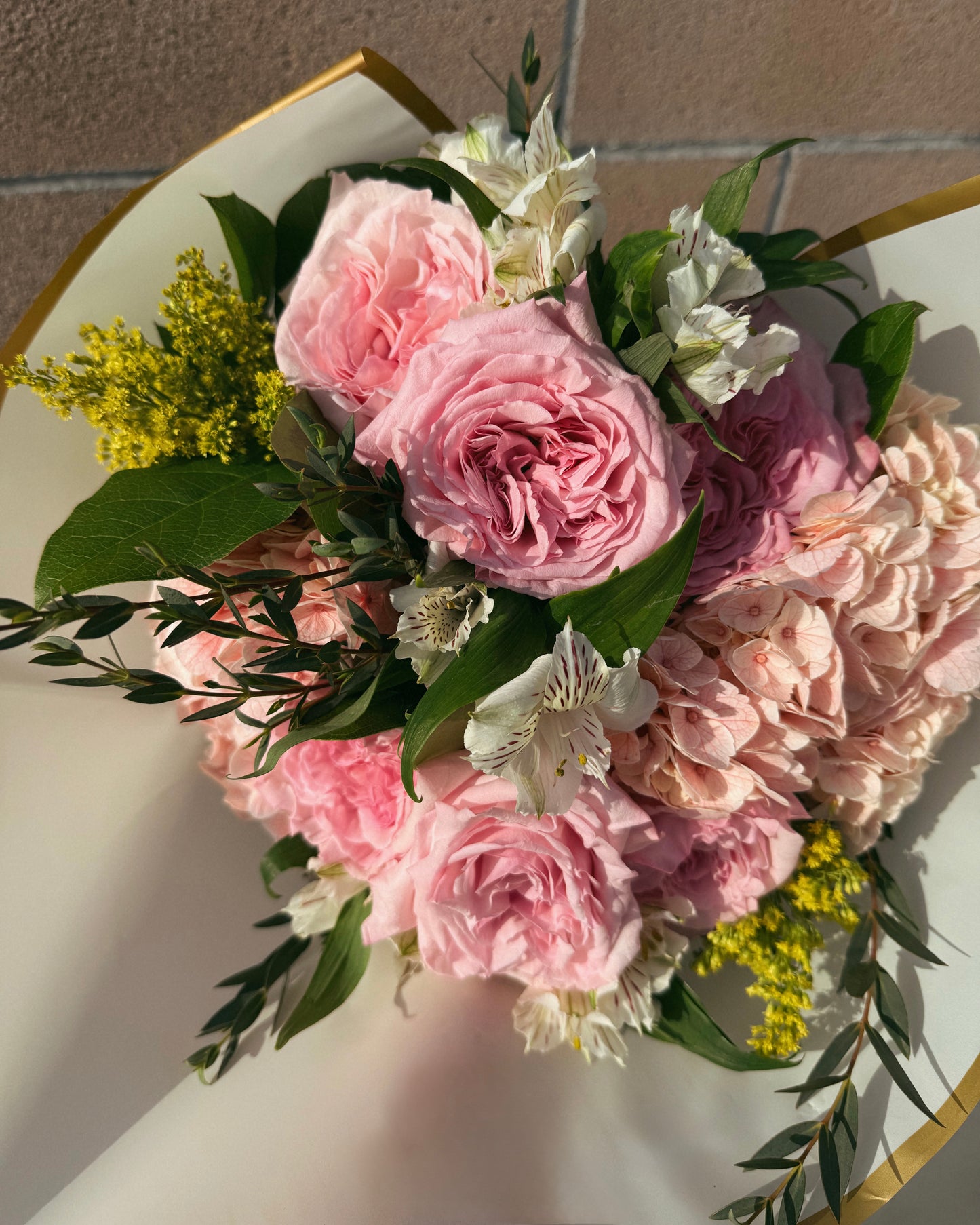 Bouquet of luxurious pink and white flowers, garden roses, lush hydrangeas and mix deluxe flowers with greenery.