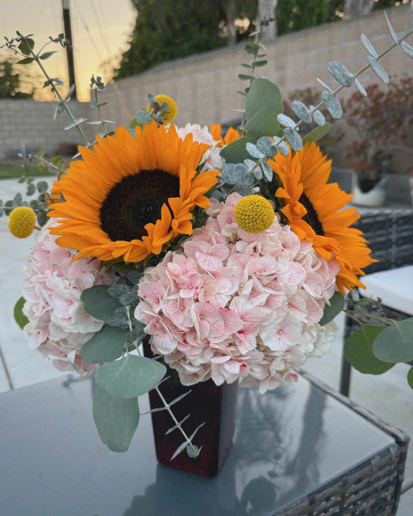 Bouquet of flowers with sunflowers and hydrangeas on a reflective surface