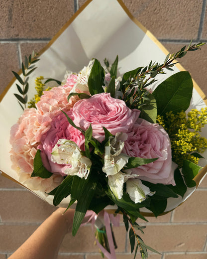 Bouquet of luxurious pink and white flowers, garden roses, lush hydrangeas and mix deluxe flowers with greenery.