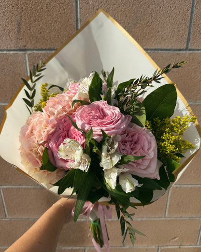 Bouquet of luxurious pink and white flowers, garden roses, lush hydrangeas and mix deluxe flowers with greenery.