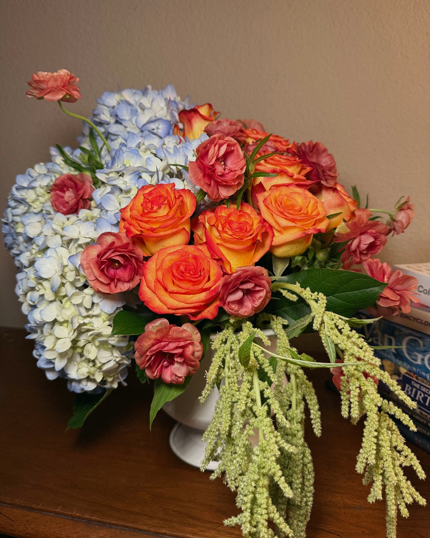 A deluxe bouquet of flowers, including roses and hydrangeas, thoughtfully arranged in a vase by Superbloom floral.