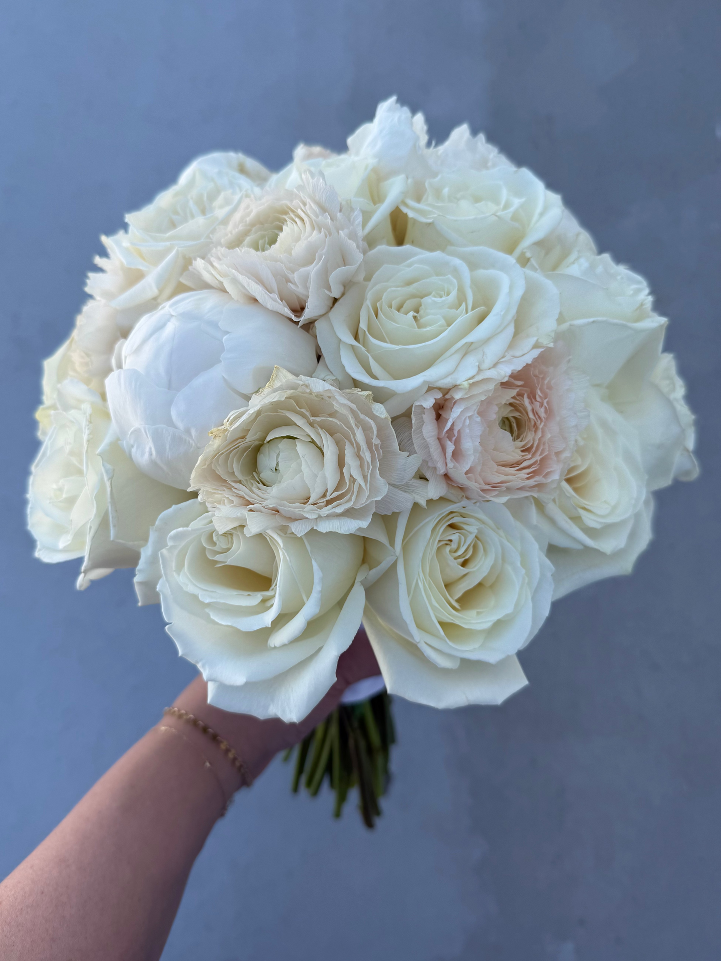 classic style bridal bouquet crafted with ranunculus, roses, and peony
