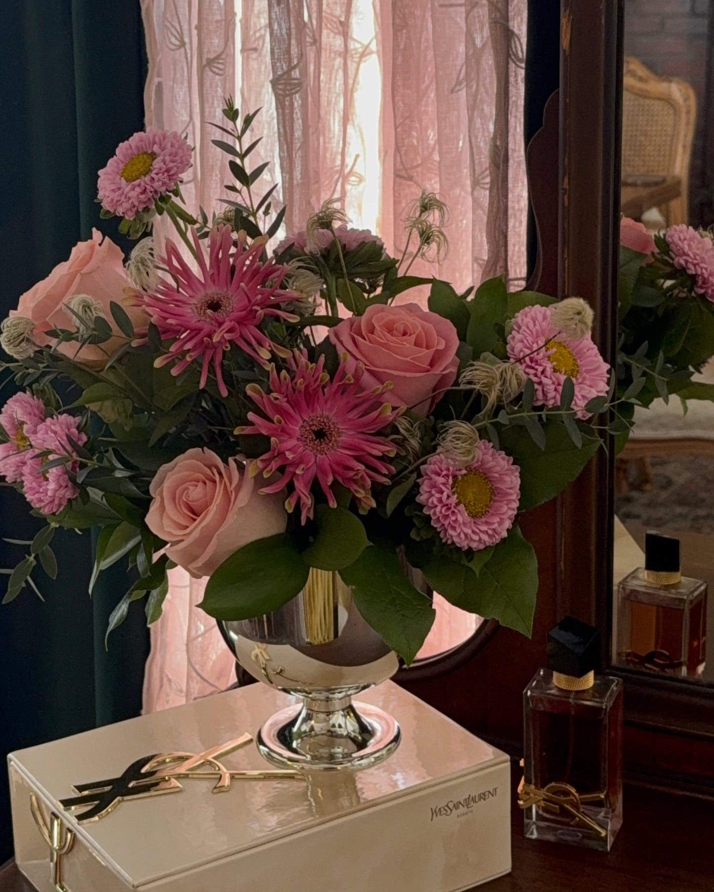 blush roses, spider gerbers, asters, and greens arranged in a vase.