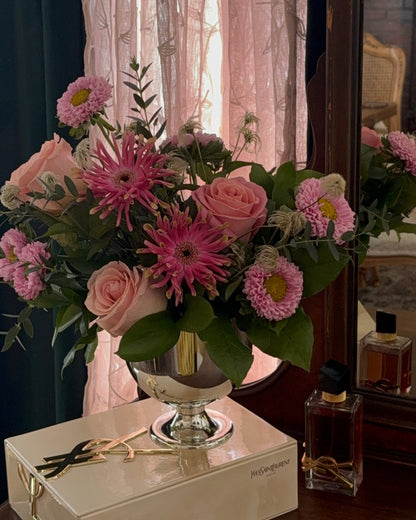 blush roses, spider gerbers, asters, and greens arranged in a vase.