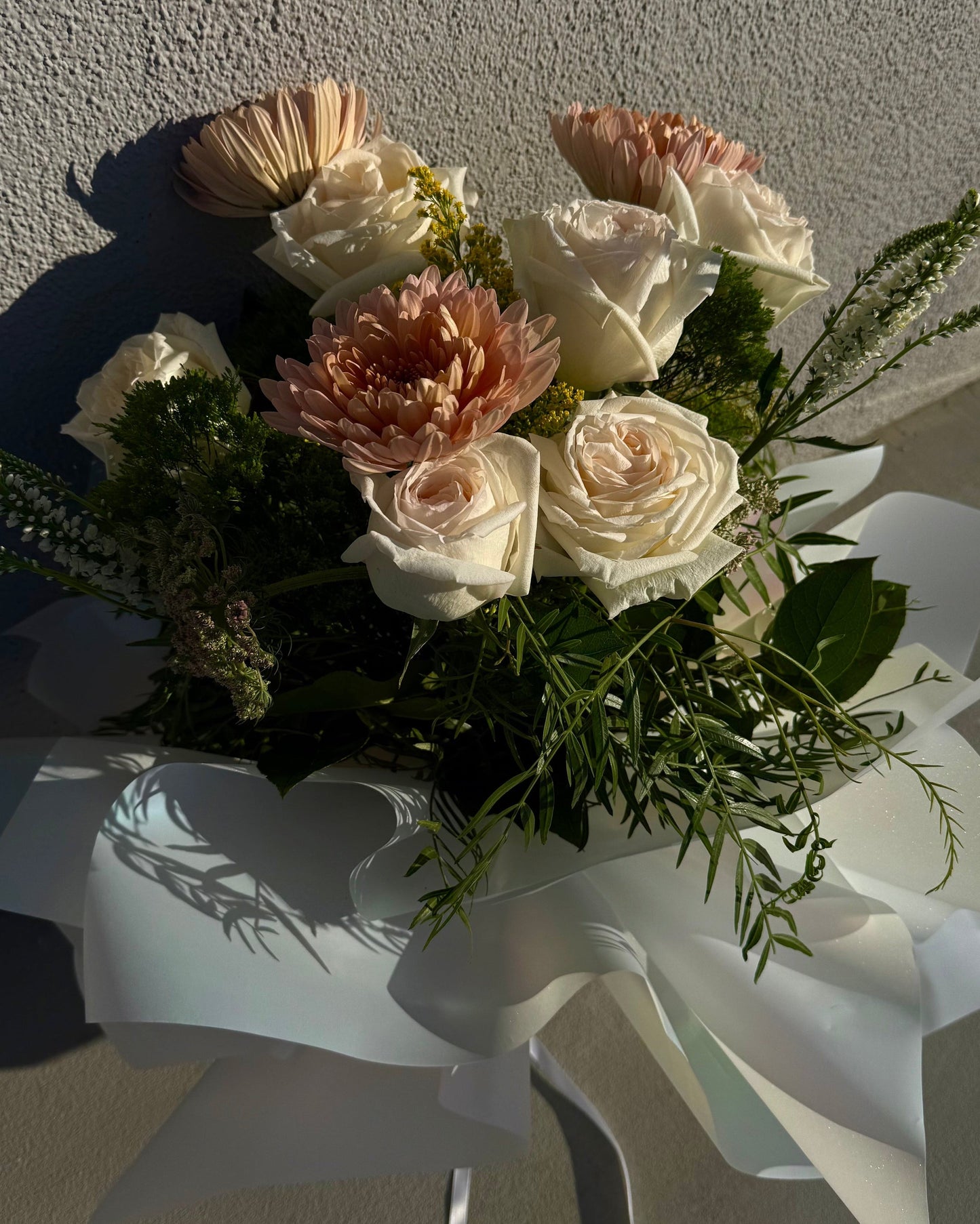 Bouquet of luxurious mauve and white flowers, garden roses, lush fuji mums and mix deluxe flowers with greenery.