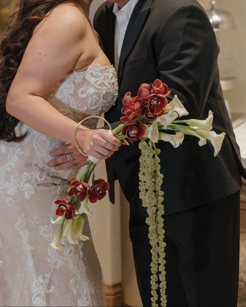 Superbloom Floral purse bouquet crafted from calla lilies, cymbudium orchids and amaranthus.