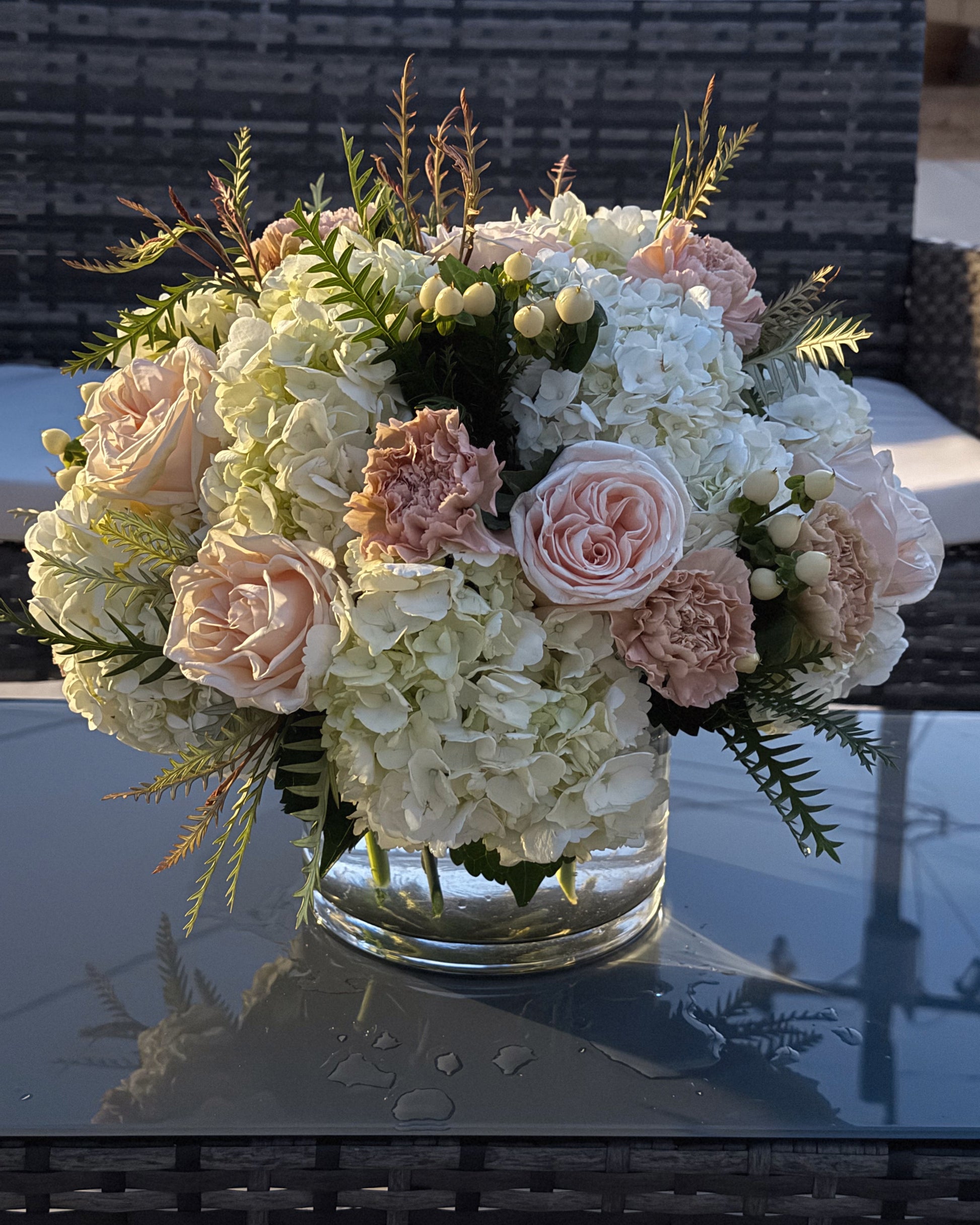 Superbloom Floral, Southern California Mobile Flower Shop bouquet of flowers in a clear vase on a reflective surface with a blurred background