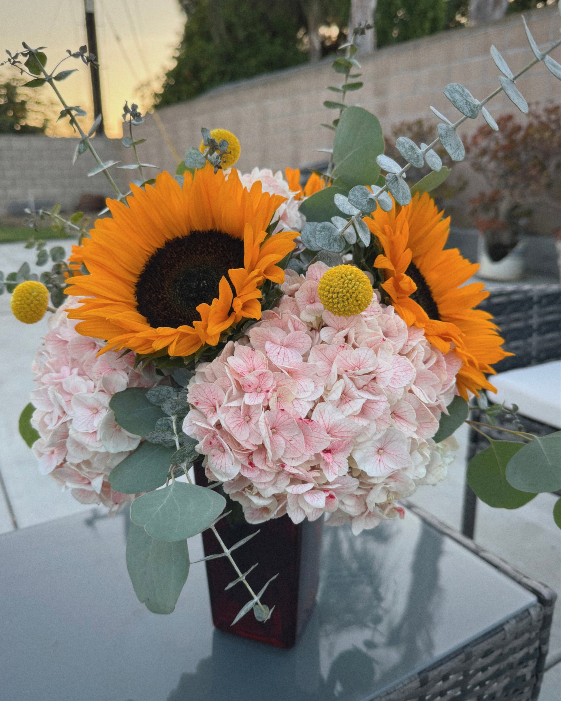 Bouquet of flowers with sunflowers and hydrangeas on a reflective surface