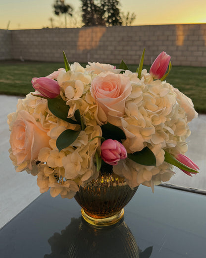 Bouquet of flowers in a vase on a reflective surface with a blurred background