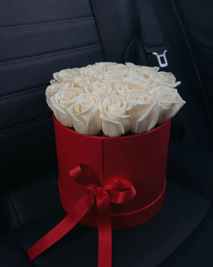 Bouquet of white roses in a red box on a car seat