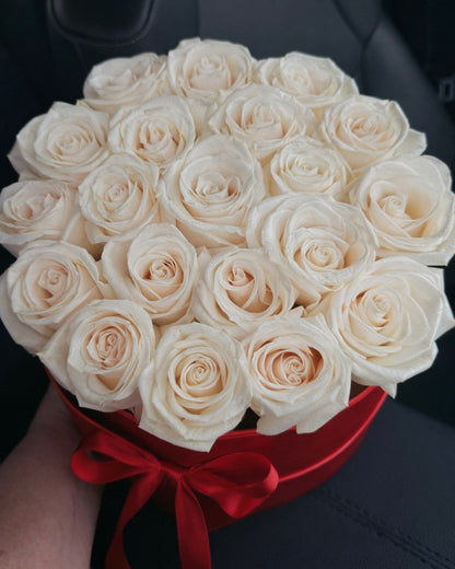 Bouquet of white roses in a red box on a car seat