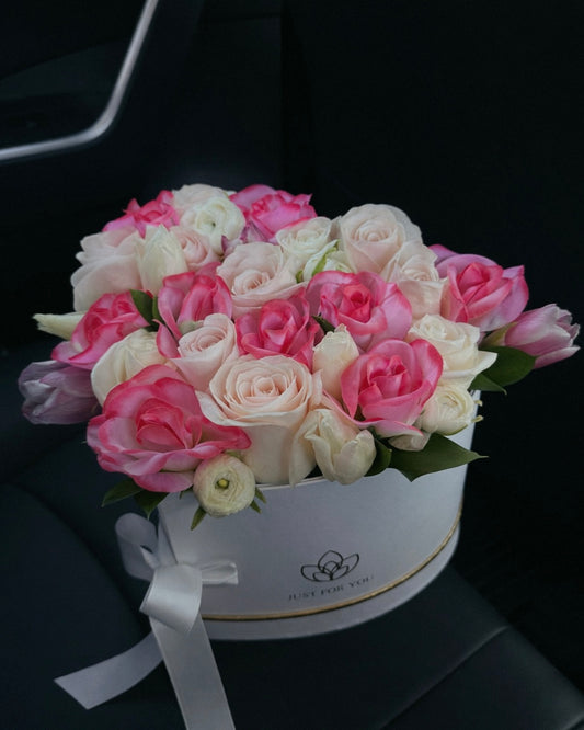 Bouquet of mixed pink and white florals in a white box on a car seat