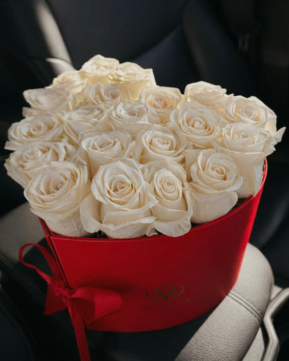 Bouquet of white roses in a red box on a car seat