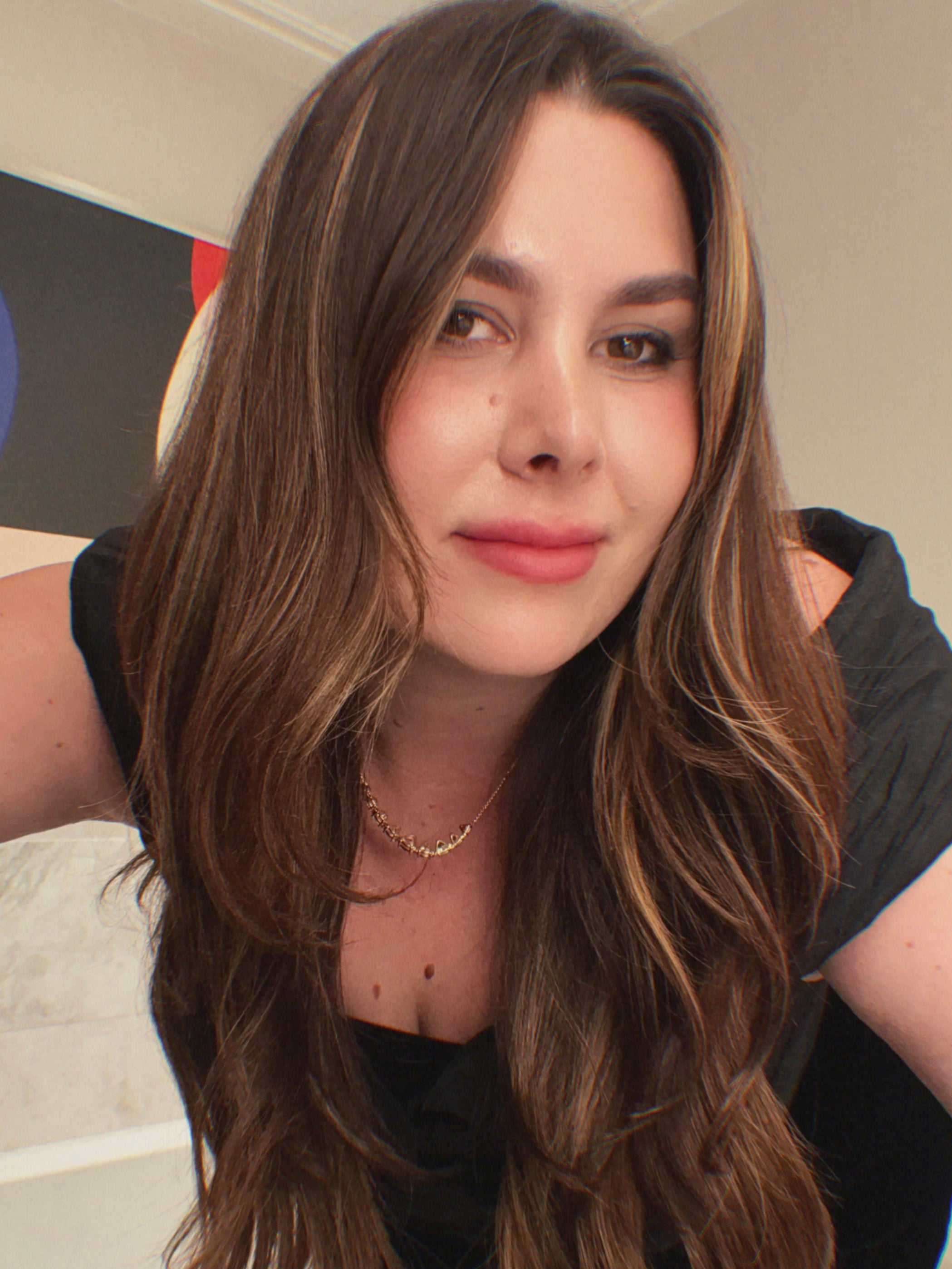 Superbloom Floral owner, Becca Hearn. A woman with long brown hair wearing a black top in an indoor setting.