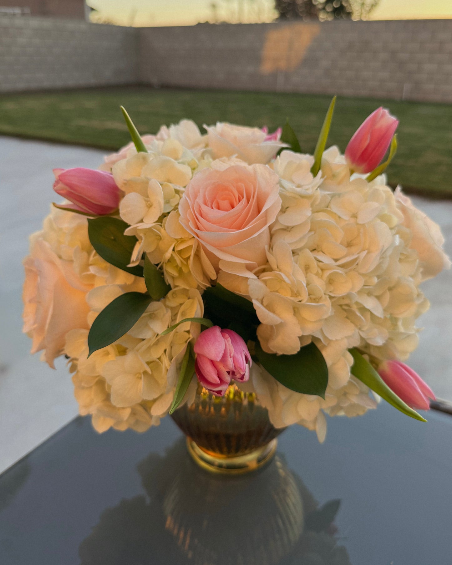 Bouquet of flowers in a vase on a reflective surface