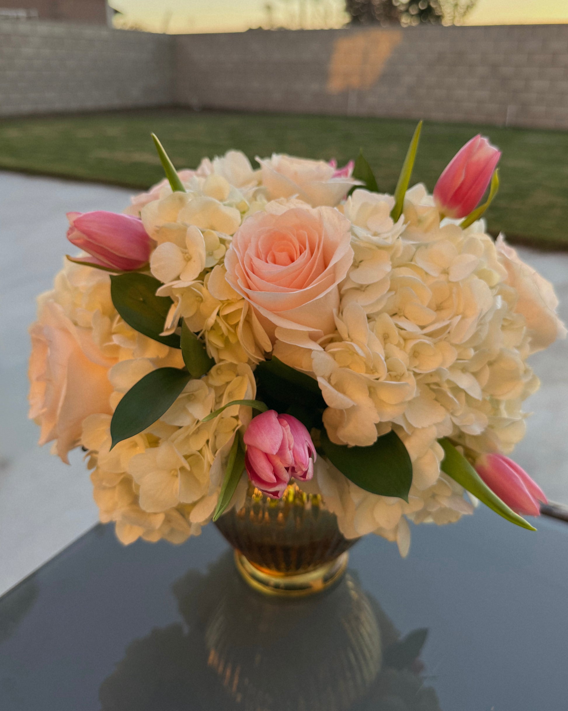 Bouquet of flowers in a vase on a reflective surface